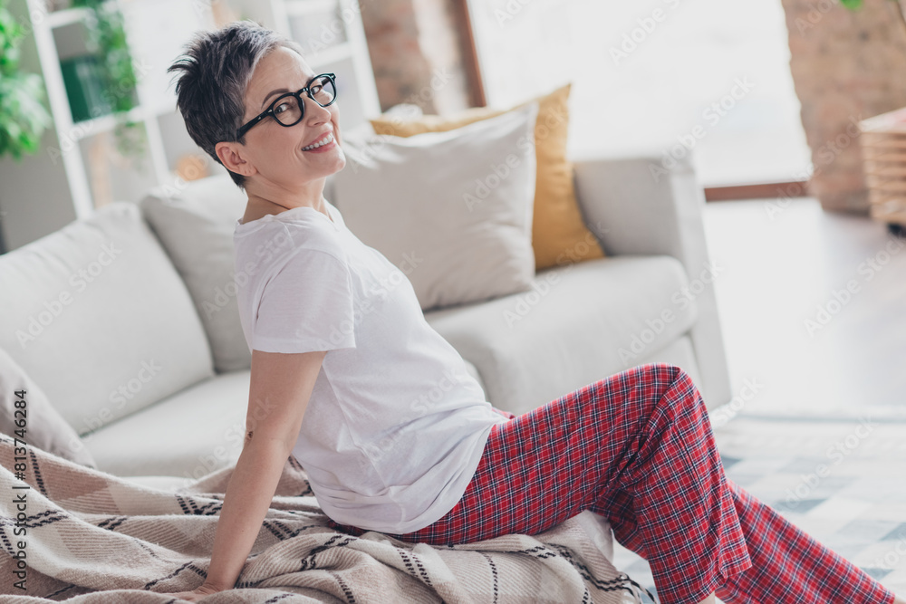 Photo of lovely mature lady sit sofa dressed white garment modern living room rest enjoy weekend free leisure time alone home Photo of lovely mature lady sit sofa dressed white garment modern living room rest enjoy weekend free leisure time alone home