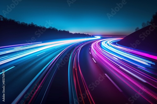 A long exposure shot captures colorful light trails from vehicles moving swiftly on a highway during the night.