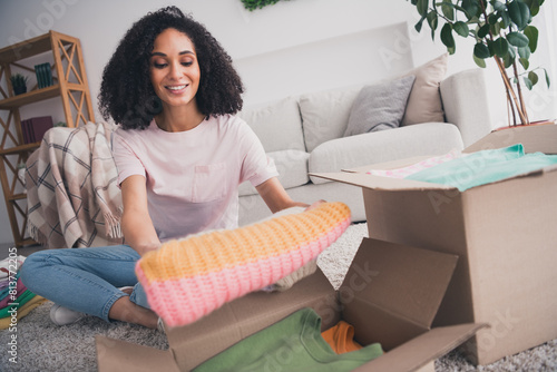 Photo of lovely cute girl wearing trendy clothes sitting floor packing parcel package preparing relocation indoors photo