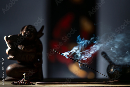 Asian incense stick in stick holder burning with smoke on dark background, closeup. Meditation, yoga, self development and sound therapy concept