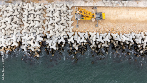 Aerial view of breakwater construction. Crane puts tetrapods on breakwater construction photo