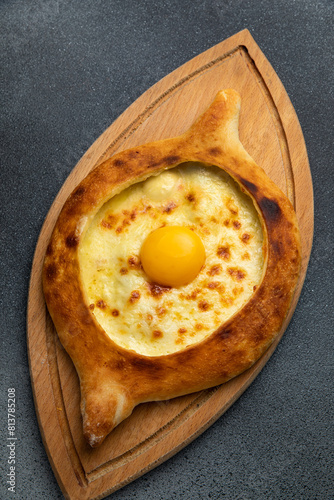 Georgian khachapuri with egg yolk on wooden board