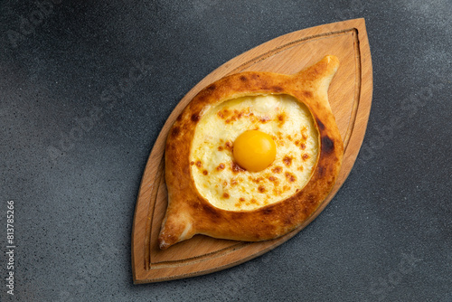 Georgian khachapuri with egg yolk on wooden board