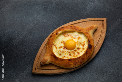 Georgian khachapuri with egg yolk on wooden board © Борис Яценко