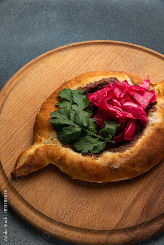 Traditional georgian khachapuri with red cabbage on wooden board