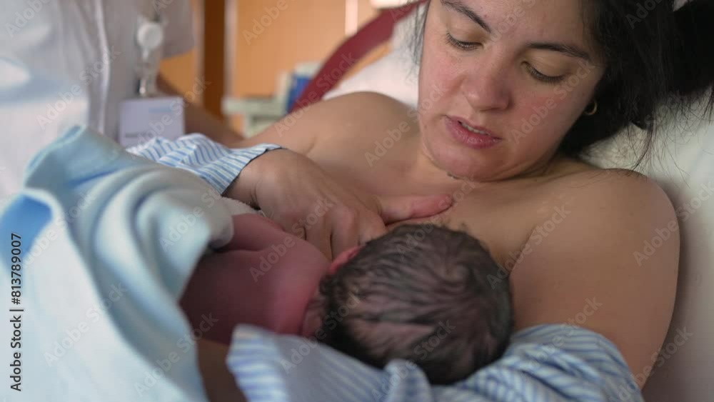 Mother breastfeeds newborn baby for the first time at hospital clinic, authentic real life mom feeding her infant in the first minutes of life, maternal care and growth