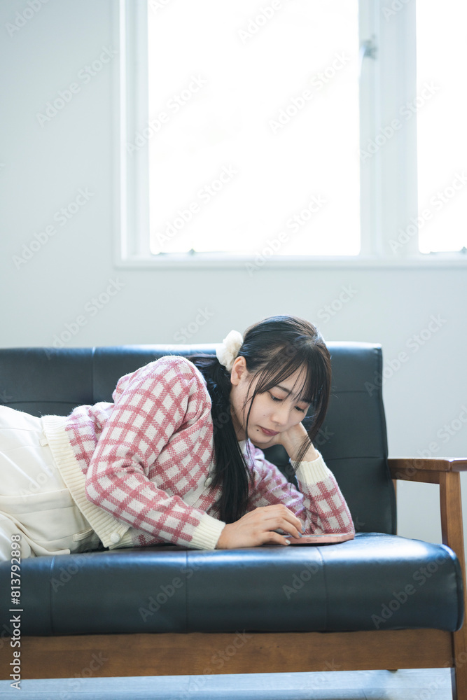 Obraz premium スマートフォンを使い若い女性