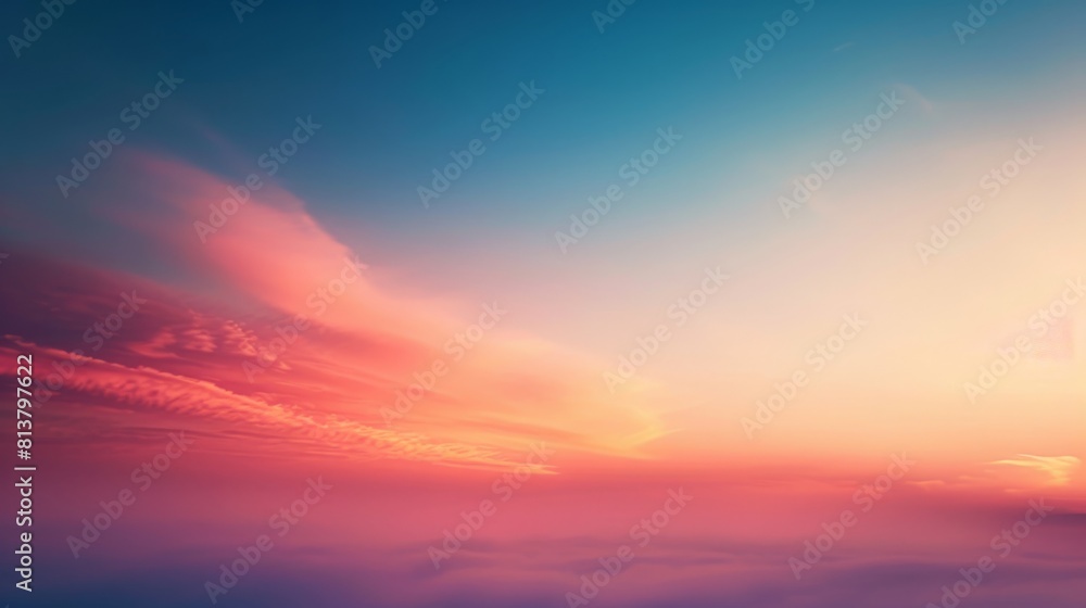 A serene sky painted with a gradient of orange and blue hues as the sun sets, with soft clouds.