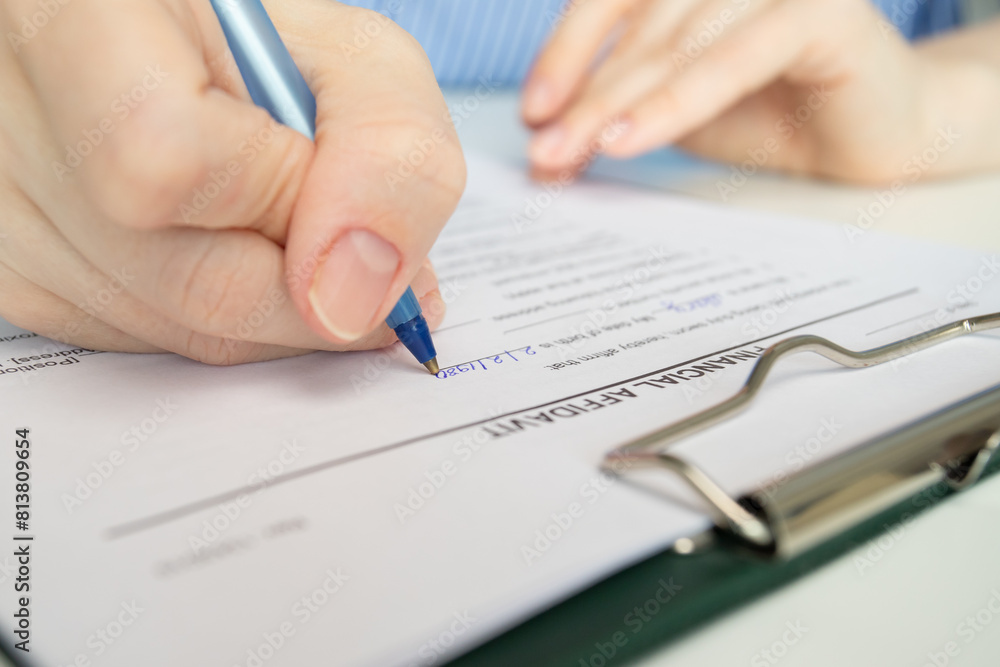 Financial affidavit, hand fills out a document, accounting statement, analysis. Financial affidavit, hand fills out a document, accounting statement, analysis.