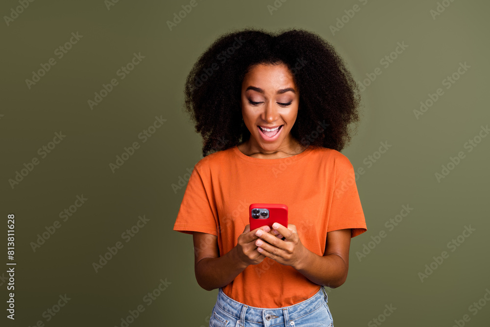 Photo of shiny attractive lady dressed orange outfit chatting apple samsung iphone device empty space isolated khaki color background Photo of shiny attractive lady dressed orange outfit chatting apple samsung iphone device empty space isolated khaki color background