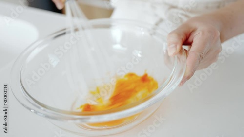 女性がボールで卵を溶いているシーン