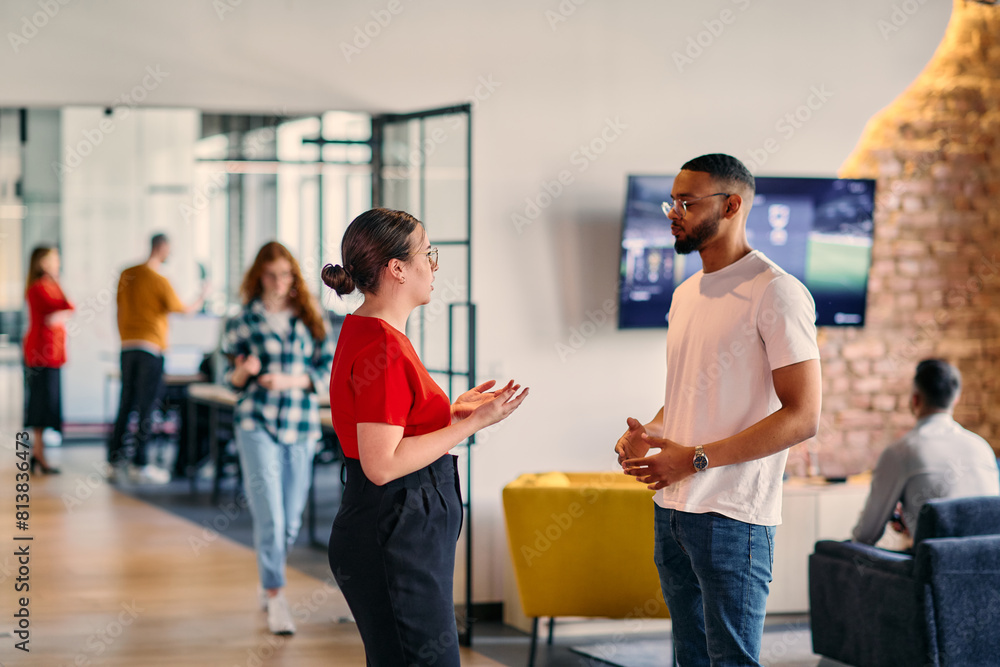Young business colleagues, including an African American businessman, engage in a conversation about business issues in the hallway of a modern startup coworking center, exemplifying dynamic problem Young business colleagues, including an African American businessman, engage in a conversation about business issues in the hallway of a modern startup coworking center, exemplifying dynamic problem