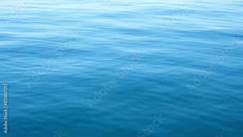 Continuously changing deep blue sea or ocean surface for a background. Beautiful fresh wavy water on a cloudy afternoon. Calm and meditative nature concept. Abstract minimalistic slow motion.