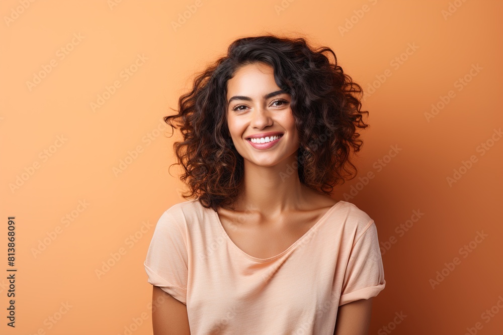 A woman with curly hair is smiling and wearing a pink shirt A woman with curly hair is smiling and wearing a pink shirt