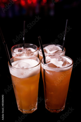 Four yellow cocktails with ice in glasses. Mixing an alcoholic cocktail in a nightclub, pub, restaurant