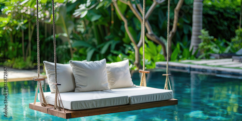 Close-up Minimal Beautiful Swing sofa on the Swimming pool water on outdoor beach in tropical hotel.