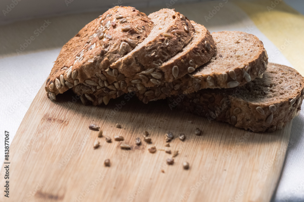 Cereal bread cut into pieces on a wooden board. Healthy eating. Close-up.