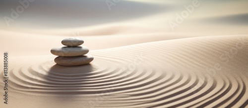 A tranquil zen garden with stacked stones set on sand forming a beautiful pattern The serene image offers a space for text and inspires meditation and harmony. Copy space image
