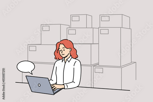 Woman small business owner works sitting near computer and boxes, selling goods through online store. Girl owner of internet supermarket does fulfillment on own located in warehouse