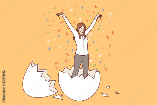 Business woman hatched from egg raises hands up, for concept of birth of new professional. Business triumph of successful businesswoman standing among confetti and rejoicing at revival