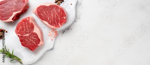 Top view of raw pork medallion steaks on a white stone table providing a clean and minimalistic background for potential text placement. Copy space image. Place for adding text and design