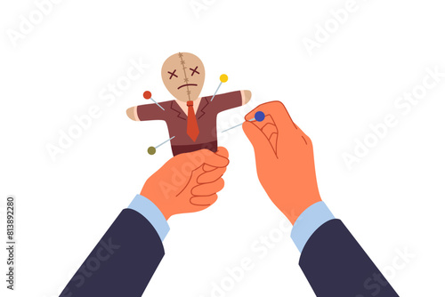 Voodoo doll in hands of business man who uses black magic and pagan curses for unfair competition. Vindictive guy pierces voodoo doll with needles, wanting to make enemy or competitor suffer