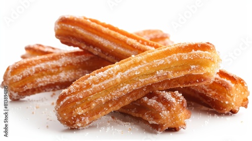 Image description:.Four golden churros on a white background. The churros are sprinkled with sugar and have a crispy texture.