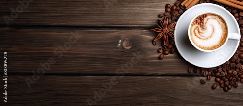 On a wooden table there is a cup of hot drink topped with aromatic cinnamon and whipped cream creating a visually appealing flat lay There is ample space for text in the image