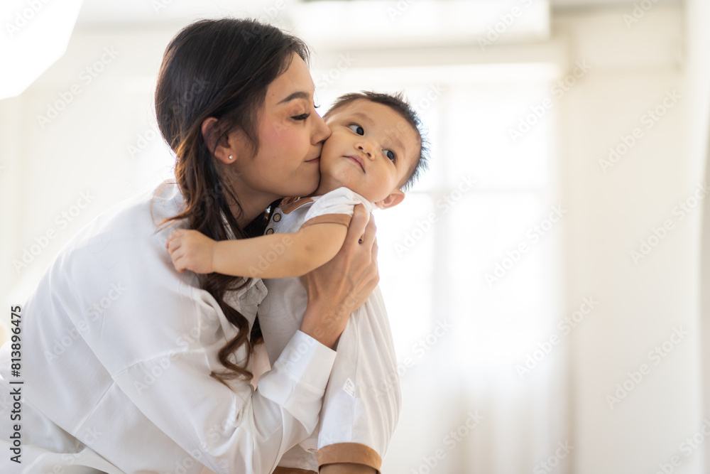 Portrait of enjoy happy love family asian mother playing with adorable little asian baby.Mom touching with cute son moments good time in a white bedroom.Love of family concept Portrait of enjoy happy love family asian mother playing with adorable little asian baby.Mom touching with cute son moments good time in a white bedroom.Love of family concept