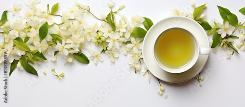 A top view of a cup of green jasmine tea with jasmine flowers on a white background creating a teatime concept Perfect for copy space image