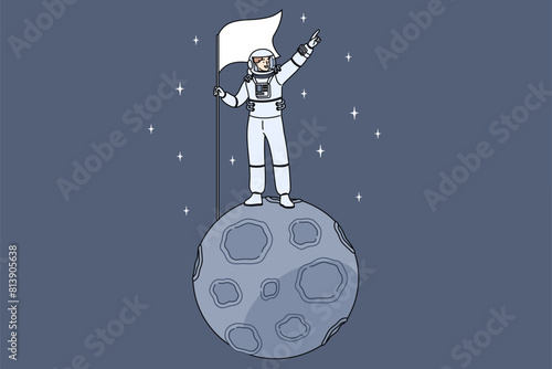Man astronaut stands on miniature moon in space and holds flag pointing towards endless galaxy. Astronaut guy dressed in spacesuit who was in orbit for first time and went into open cosmos