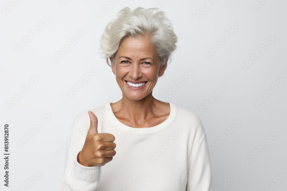 Portrait of a happy woman in her 40s showing a thumb up over white background Portrait of a happy woman in her 40s showing a thumb up over white background