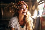 Joyful young woman with curly hair and headband laughs heartily in a cozy, sunlit setting