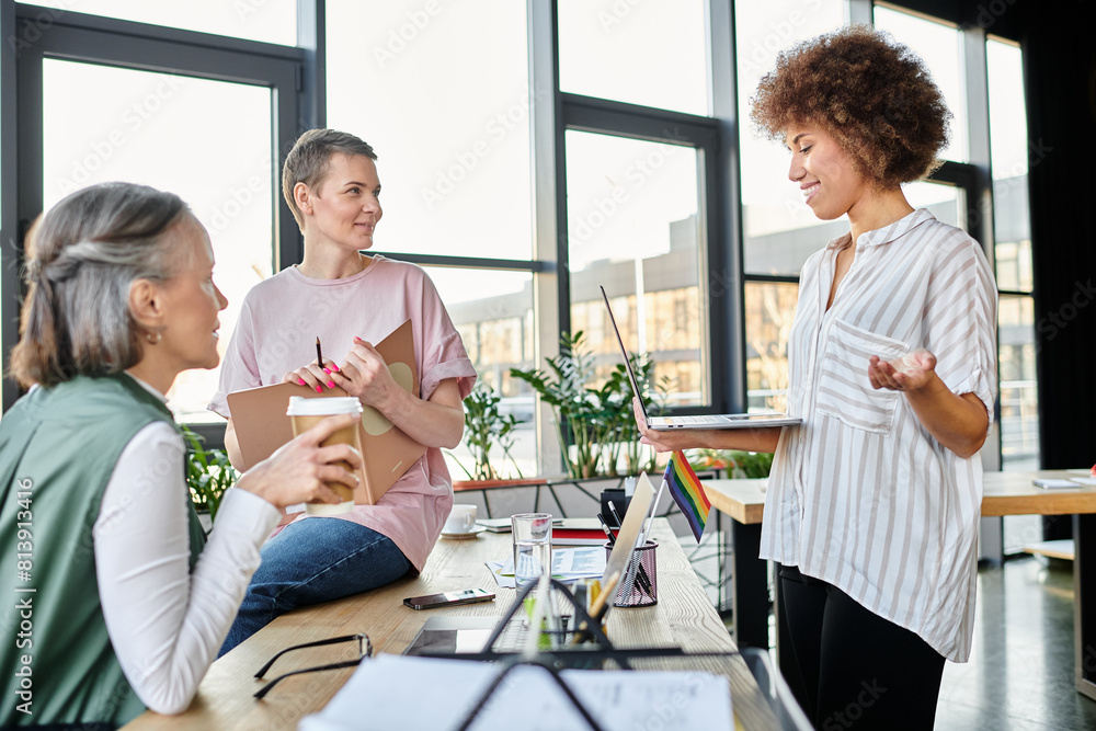 A diverse group of hardworking busnesswomen engaging in conversation around a table. A diverse group of hardworking busnesswomen engaging in conversation around a table.