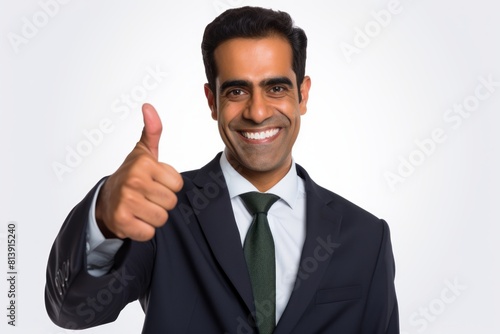 Portrait of a smiling indian man in his 40s showing a thumb up isolated on white background