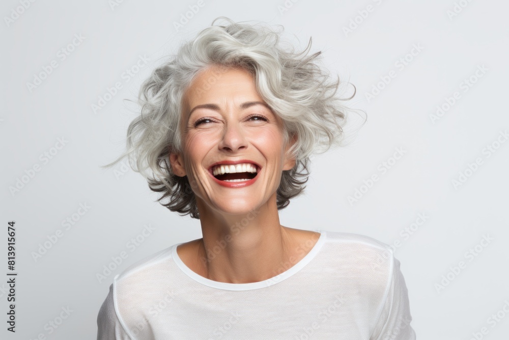 Portrait of a joyful woman in her 50s smiling at the camera isolated on white background Portrait of a joyful woman in her 50s smiling at the camera isolated on white background
