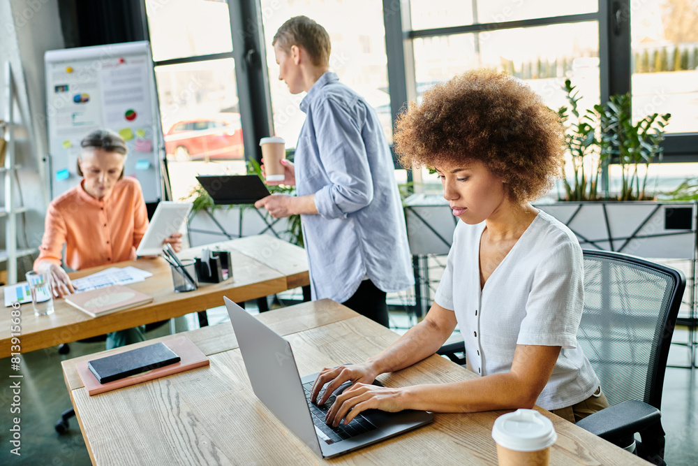 Women engrossed in work, at table in stylish setting. Women engrossed in work, at table in stylish setting.
