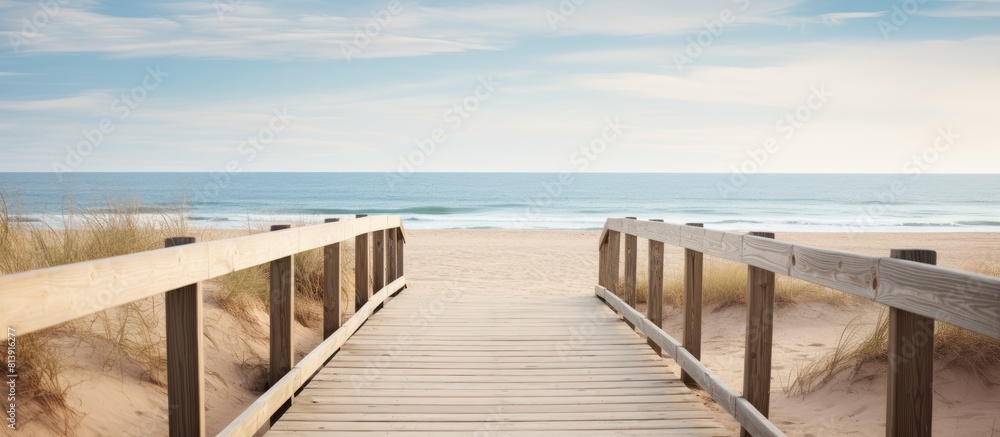 A wooden boardwalk meanders through the sandy beach providing a scenic route with plenty of copy space image potential A wooden boardwalk meanders through the sandy beach providing a scenic route with plenty of copy space image potential