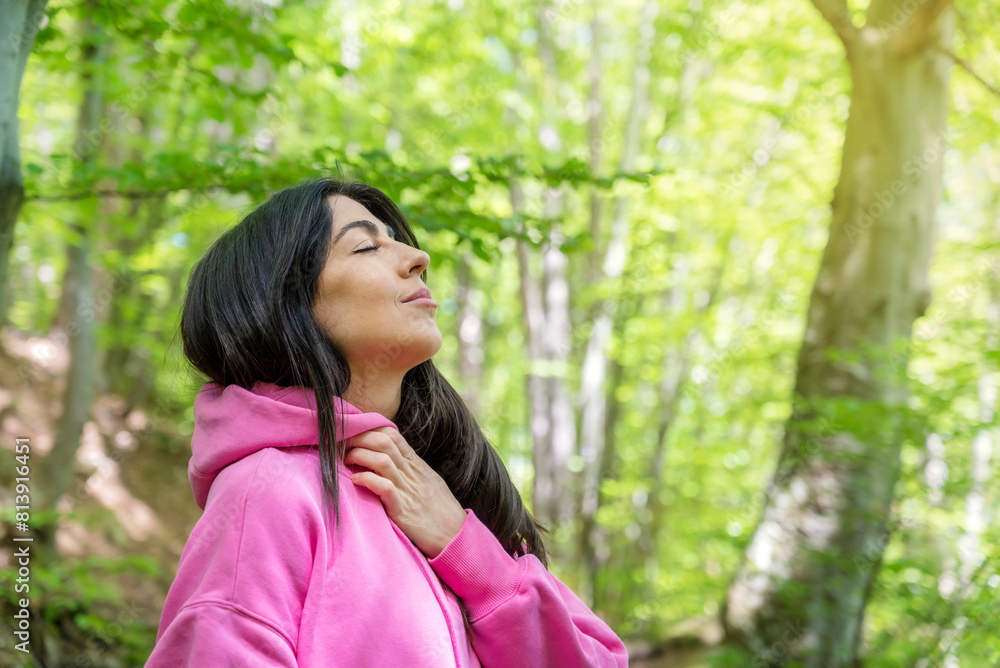Relaxed woman breathing fresh air in a green spring forest Relaxed woman breathing fresh air in a green spring forest