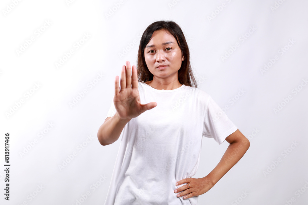 Portrait of asian woman extending one hand, stop taboo sign, rejecting, declining something, standing over white background Portrait of asian woman extending one hand, stop taboo sign, rejecting, declining something, standing over white background