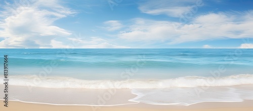 The scenic beach and tranquil blue sea with gentle waves blend harmoniously with the sky adorned in white clouds creating an idyllic seascape backdrop This copy space image is perfect for conveying t