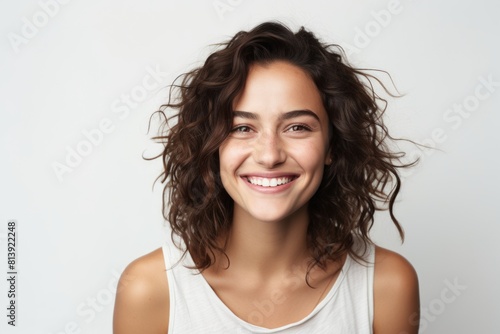 Portrait of a happy woman in her 20s smiling at the camera over white background