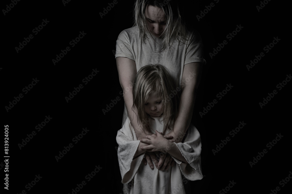 little daughter and mother are sad on a black background little daughter and mother are sad on a black background