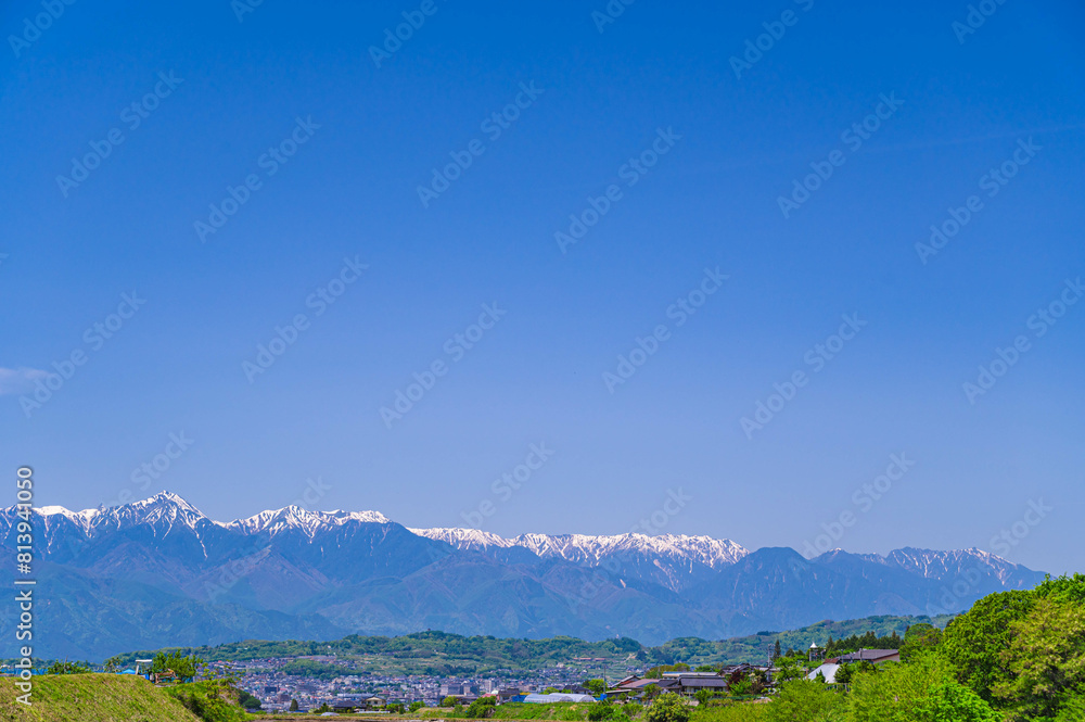 Obraz premium 春の北アルプスと山岳都市