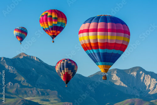 A breathtaking sight of vibrant hot air balloons drifting gracefully over a majestic mountain range, against a backdrop of clear blue skies, symbolizing adventure, and exploration © grey