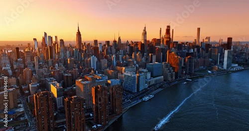 Approaching the splendid cityscape of New York coated with soft pink-orange light. Top view on metropolis at sunset. photo