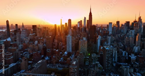 Setting sun illuminating the vast scenery of New York. Stunning cityscape at sunset from aerial perspective.