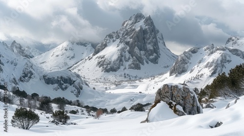 A breathtaking snowy mountain landscape under a cloudy sky with jagged peaks and gentle slopes.