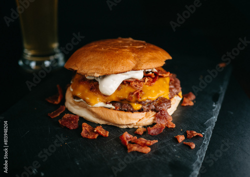 Cheese burger with bacon on black background photo