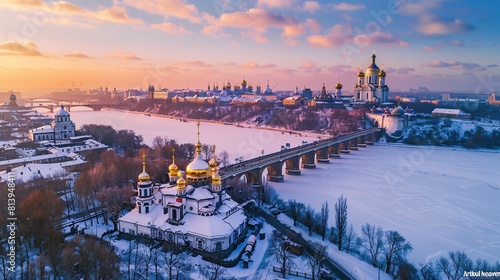 Golden domes glisten at dusk on a snowy landscape with a bridge leading to a historical monastery photo